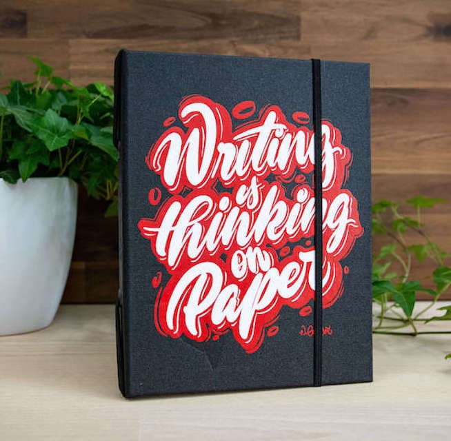 Dark grey eisvøgel cover screen-printed with the hand-lettered phrase Writing is thinking on paper.